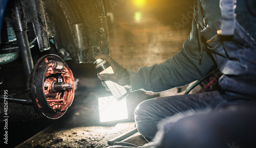 auto mechanic treats the brake pads with a spray of copper grease, a high-temperature grease for bolts and gears.