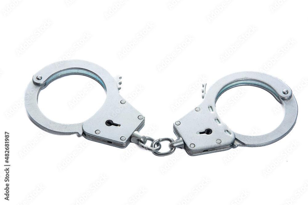 Metal handcuffs on a white isolated background Metal handcuffs on a white isolated background