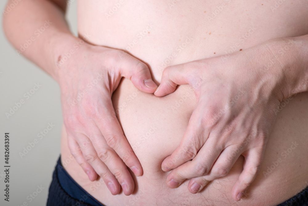 Hand's man touching his fat belly skin. Hand's man touching his fat belly skin.
