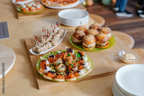 Canapes with cheese balls topped with sesame seeds. Cheese appetizer for the festive table. Food at a youth party.
