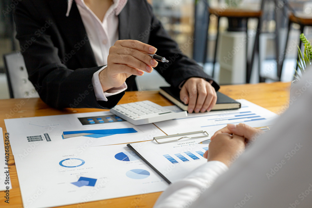 Two businessmen are reviewing the earnings summary and company financial documents that each department produces and submits for monthly audits. Concept of checking company information sheet. Two businessmen are reviewing the earnings summary and company financial documents that each department produces and submits for monthly audits. Concept of checking company information sheet.