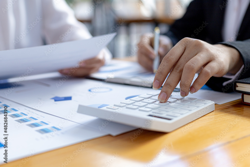 Two businessmen are reviewing the earnings summary and company financial documents that each department produces and submits for monthly audits. Concept of checking company information sheet. Two businessmen are reviewing the earnings summary and company financial documents that each department produces and submits for monthly audits. Concept of checking company information sheet.