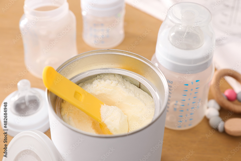 Can of powdered infant formula with scoop on table, closeup. Baby milk Can of powdered infant formula with scoop on table, closeup. Baby milk