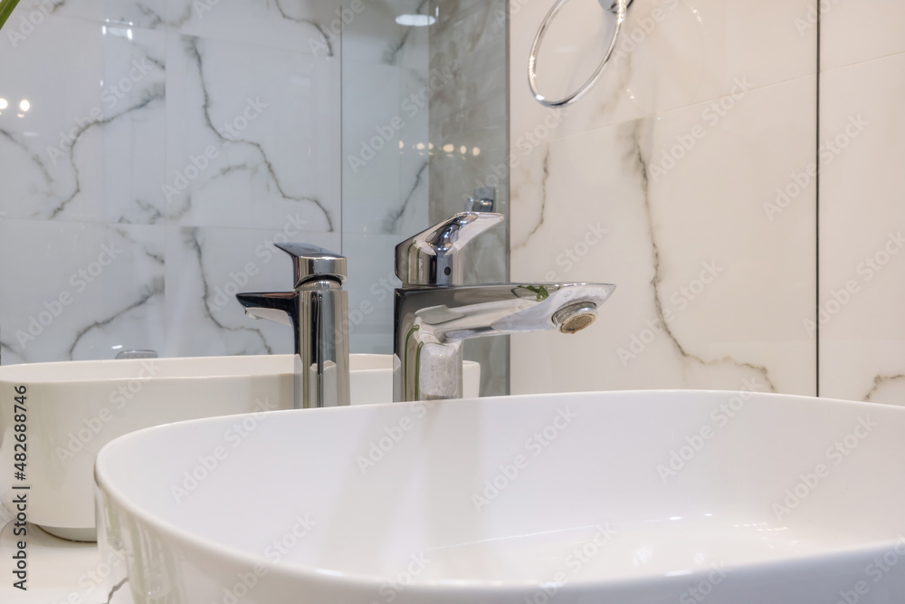 metal water tap with sink and faucet to turn on and regulate cold or hot water in expensive bathroom. metal water tap with sink and faucet to turn on and regulate cold or hot water in expensive bathroom.