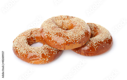 Delicious fresh bagels with sesame seeds on white background