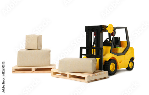 Toy forklift, wooden pallets and boxes on white background
