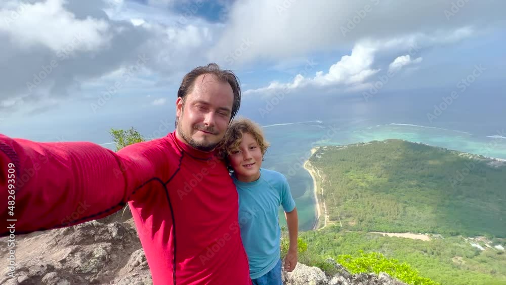 A man and his son take a selfie on Mount Le Morne Mauritius A man and his son take a selfie on Mount Le Morne Mauritius