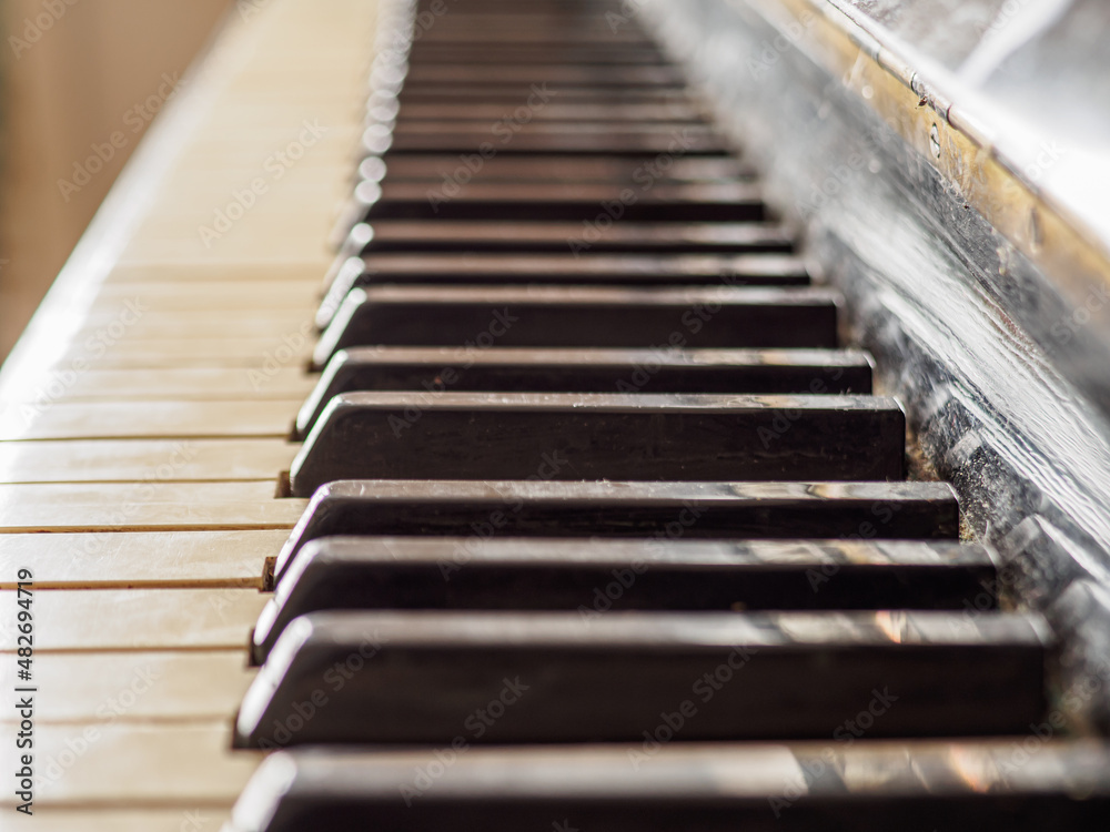 Close side view of shiny black and white old piano keys. Close side view of shiny black and white old piano keys.