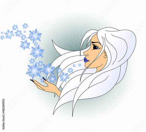 Time of the year. Cold snowy winter in the image of a woman blowing snowflakes