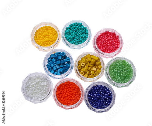 Plastic containers with different beads on white background, top view