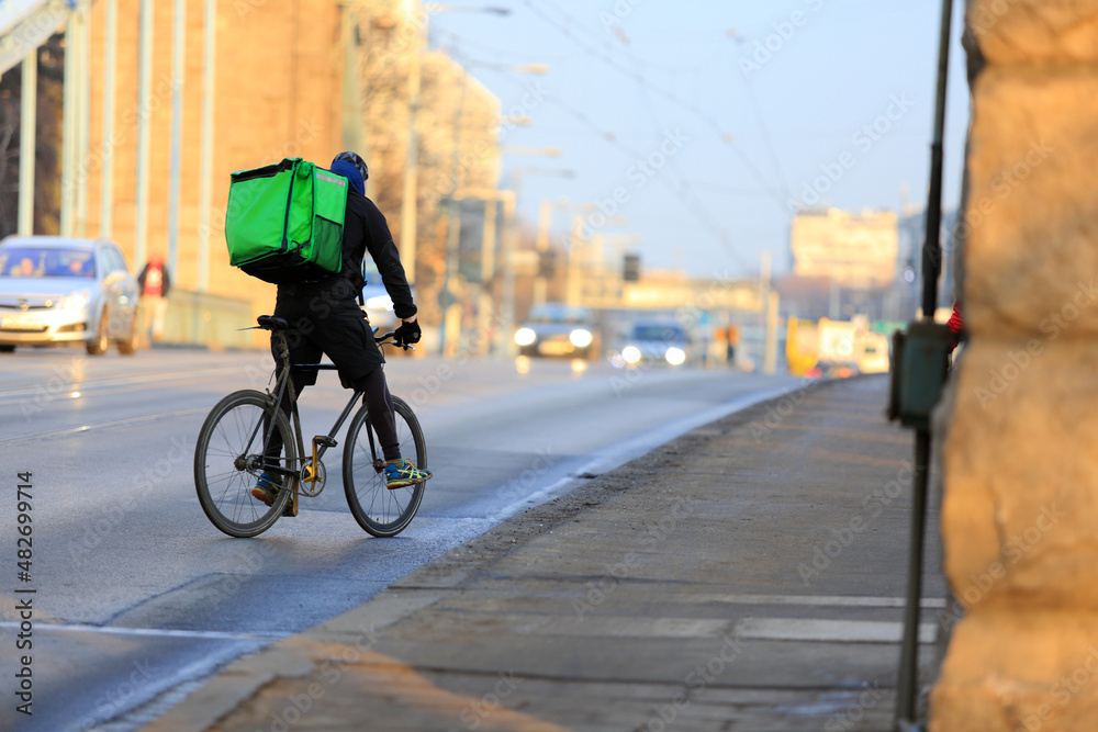 Kurier na rowerze jedzie mostem Grunwaldzkim we Wrocławiu, dostarcza jedzenie. 
 - obrazy, fototapety, plakaty 