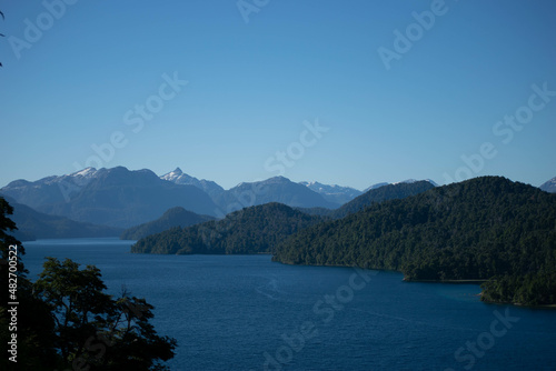 lago de agua color azul y celeste con arboles y montaña