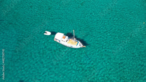 Aerial photo from traditional picturesque fishing boat on emerald clear sea as seen from top in island of Paros, Cyclades, Greece © aerial-drone