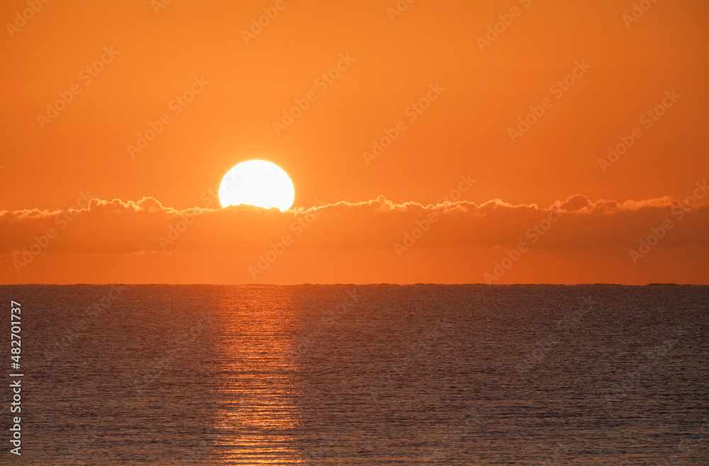 Blazing sunrise in orange sky over ocean Blazing sunrise in orange sky over ocean