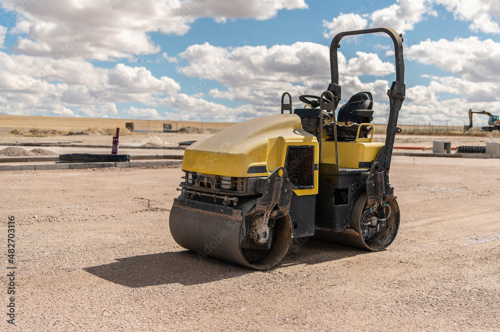 Small steamroller at a construction site, leveling the ground Small steamroller at a construction site, leveling the ground