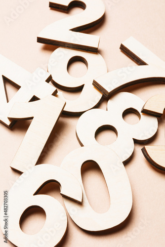 Studio shot of pile of assorted numbers against beige background photo