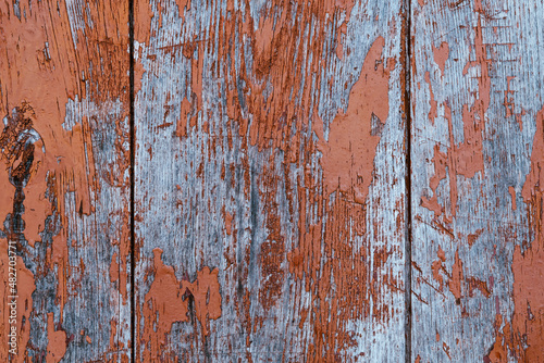 Texture of wooden boards with very worn brown paint.