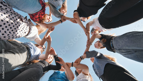A group of girls makes a circle from their palms hands.