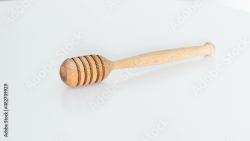 Wooden dipper for honey dripping isolated on white background