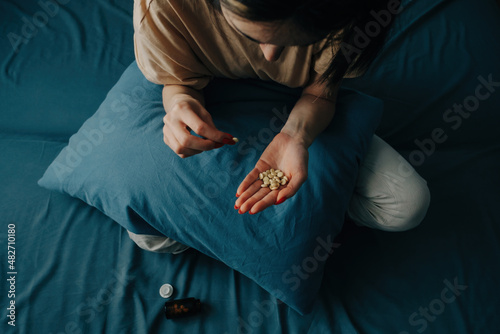 Bild auf Leinwand Sad young unrecognizable woman takes antidepressants