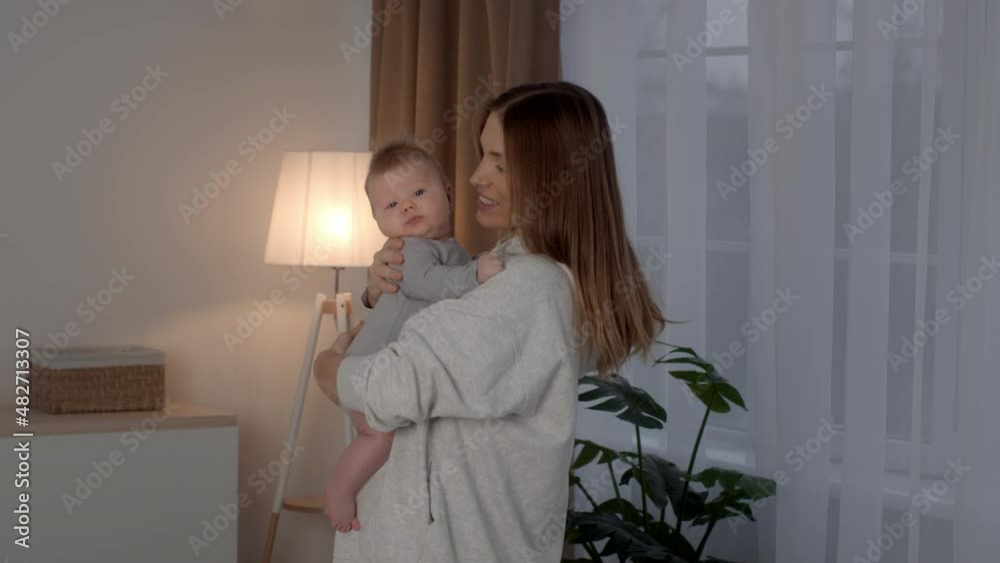Happiness Of Motherhood. Young Happy Woman Holding Adorable Newborn Baby In Arms Happiness Of Motherhood. Young Happy Woman Holding Adorable Newborn Baby In Arms