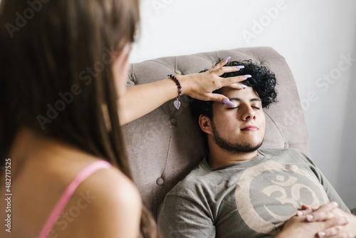 Mexican guy with closed eyes lying on the couch in regression therapy in Latin America photo