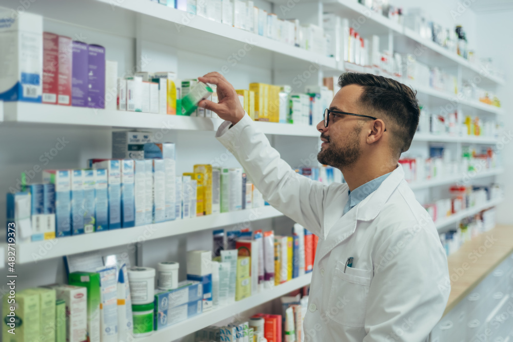 Handsome pharmacist working in a pharmacy
