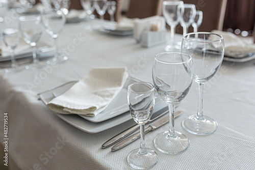 Empty table in a restaurant, served with cutlery, with a white cape