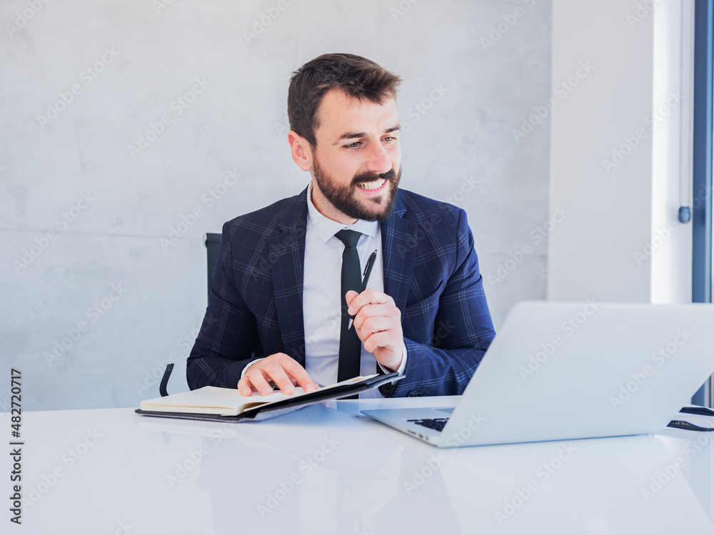 Young entrepreneur smiling while reading business mail at workplace. Young entrepreneur smiling while reading business mail at workplace.