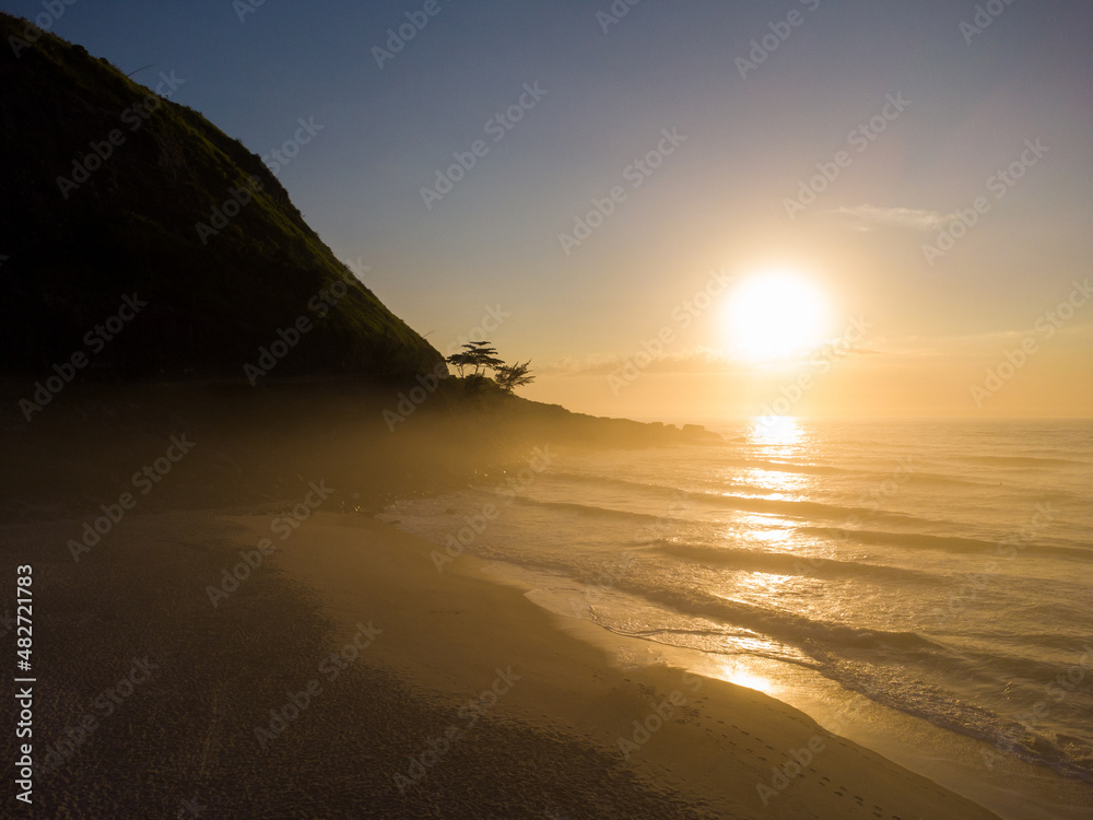 Aerial view of Prainha Beach, a paradise in the west side of Rio de Janeiro, Brazil. Big hills around. Sunny day at dawn. Greenish sea. Drone Photo