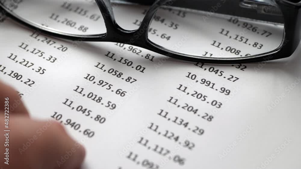 Finger tapping on financial report Finger tapping on financial report