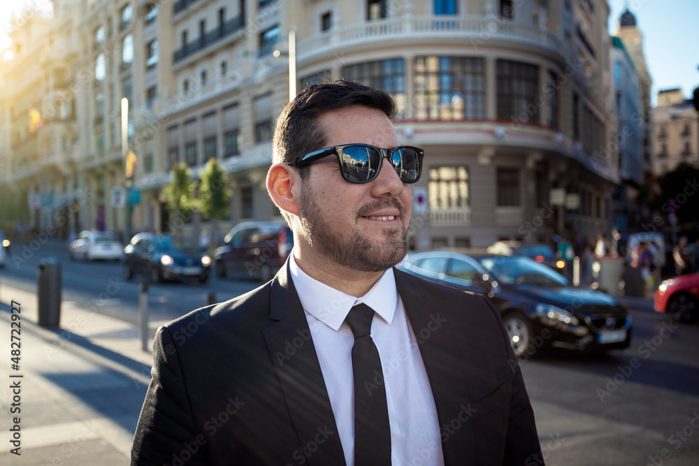 elegant and smiling dark-haired man through the streets of Madrid