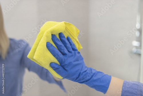 happy beautiful girl washing mirror with rag at home.House cleaning concept