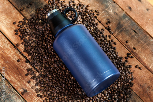 thermos with coffee in cup and coffee beans