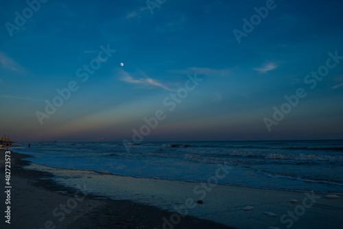 Sunset and Moonrise over the Ocean with Wave on the Beach