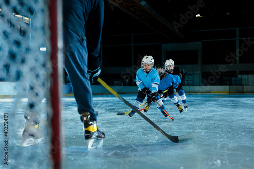 Photography Child playing ice hockey in a protection uniform