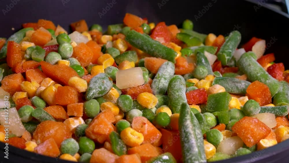 Vegetable stew. A dish of frozen vegetables is cooked in a frying pan. Asparagus, corn, pepper, peas. Vegetable stew. A dish of frozen vegetables is cooked in a frying pan. Asparagus, corn, pepper, peas.