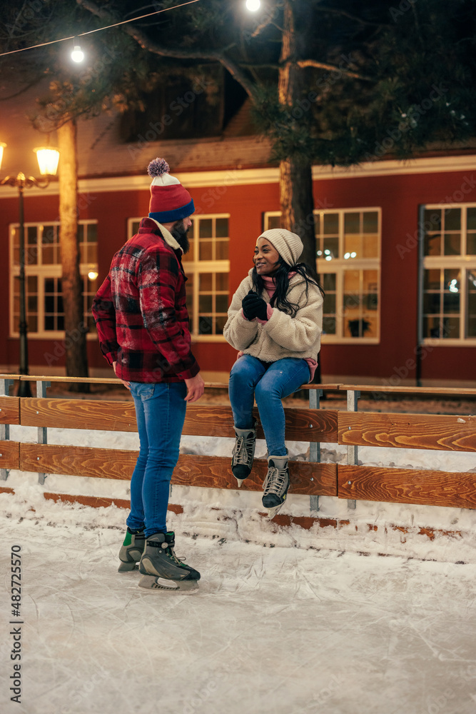 Biracial couple having date at outdoors rink