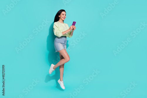 Full length photo of lady millennial jump use gadget search website discount isolated over cyan color background