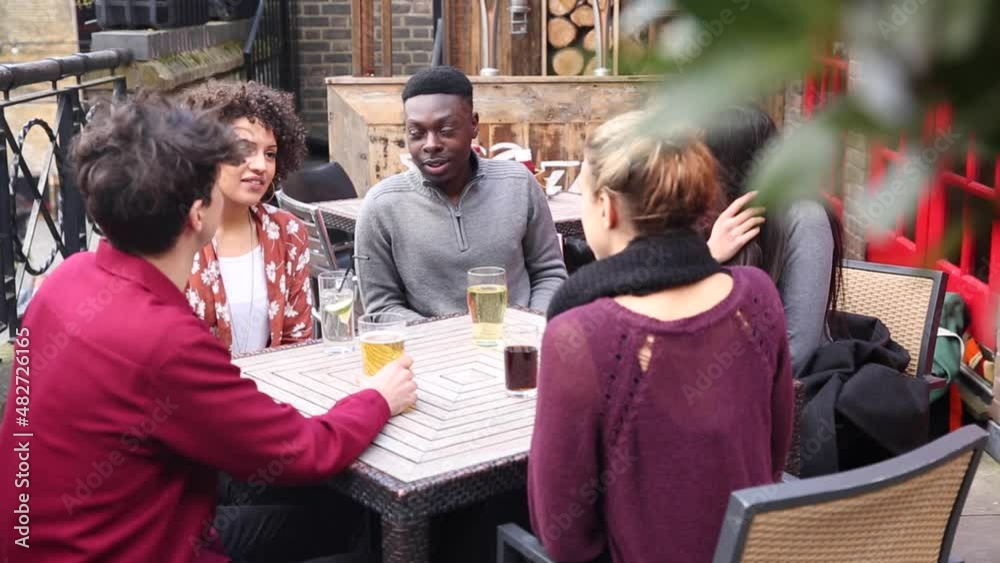 Happy multiracial group of friends enjoying drink together Happy multiracial group of friends enjoying drink together