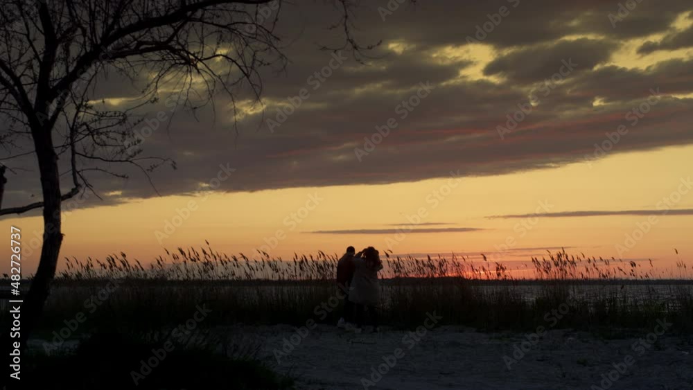 Couple walking sunset beach spending time together on nature coastline landscape Couple walking sunset beach spending time together on nature coastline landscape