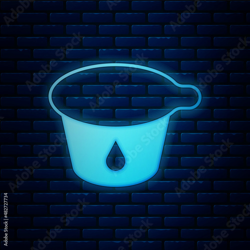 Glowing neon Yogurt container icon isolated on brick wall background. Yogurt in plastic cup. Vector