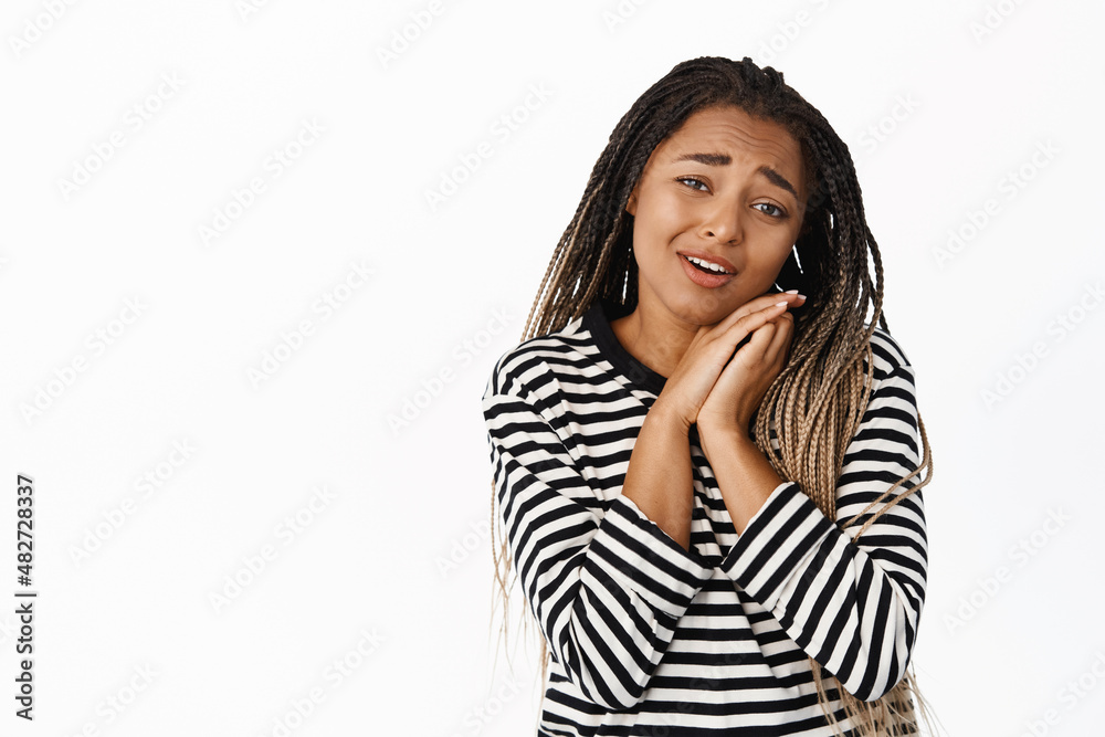 Portrait of young black woman looking at smth with care and tenderness, admiring beautiful and touching thing, heartwarming face expression, white background Portrait of young black woman looking at smth with care and tenderness, admiring beautiful and touching thing, heartwarming face expression, white background