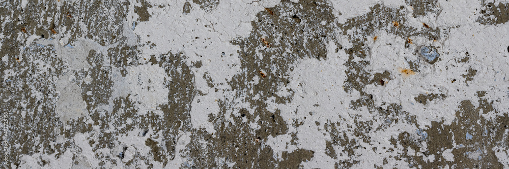 Old wall with cracked stucco. Weathered rough surface. Wide panoramic texture for background and design. Old wall with cracked stucco. Weathered rough surface. Wide panoramic texture for background and design.