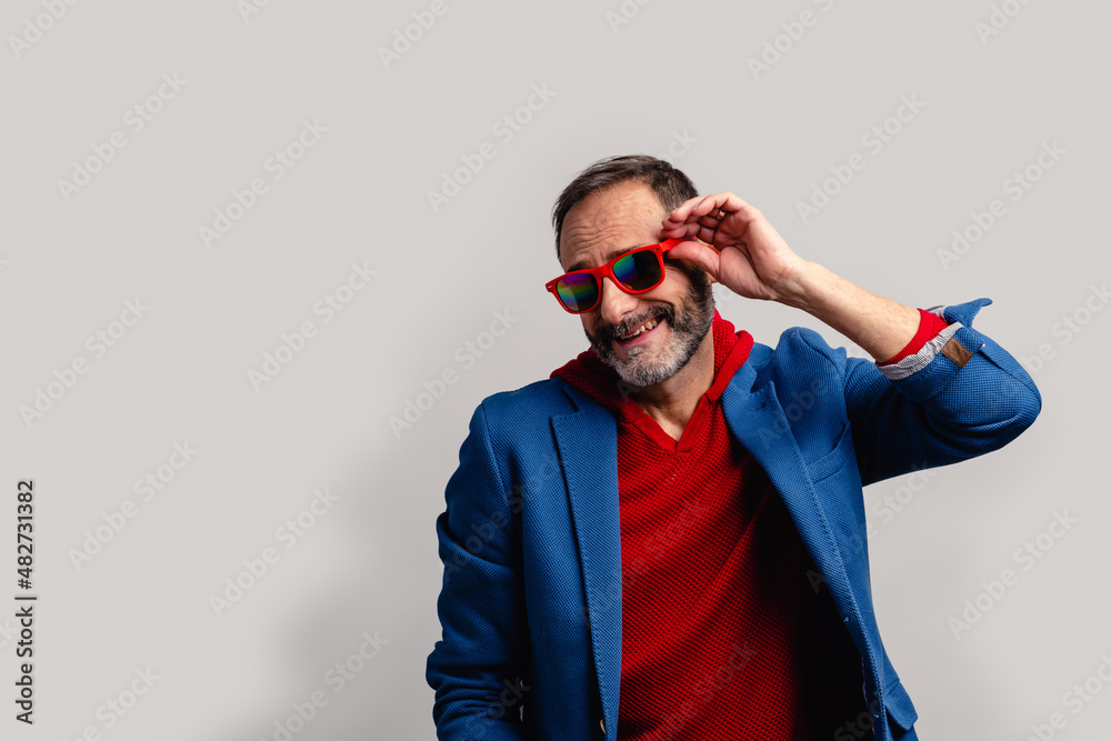 Stylish senior man peeking through sunglasses Stylish senior man peeking through sunglasses