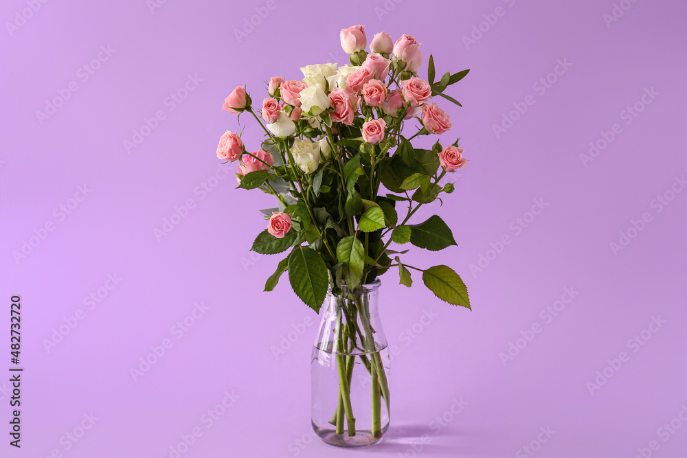 Vase with bouquet of beautiful roses on purple background