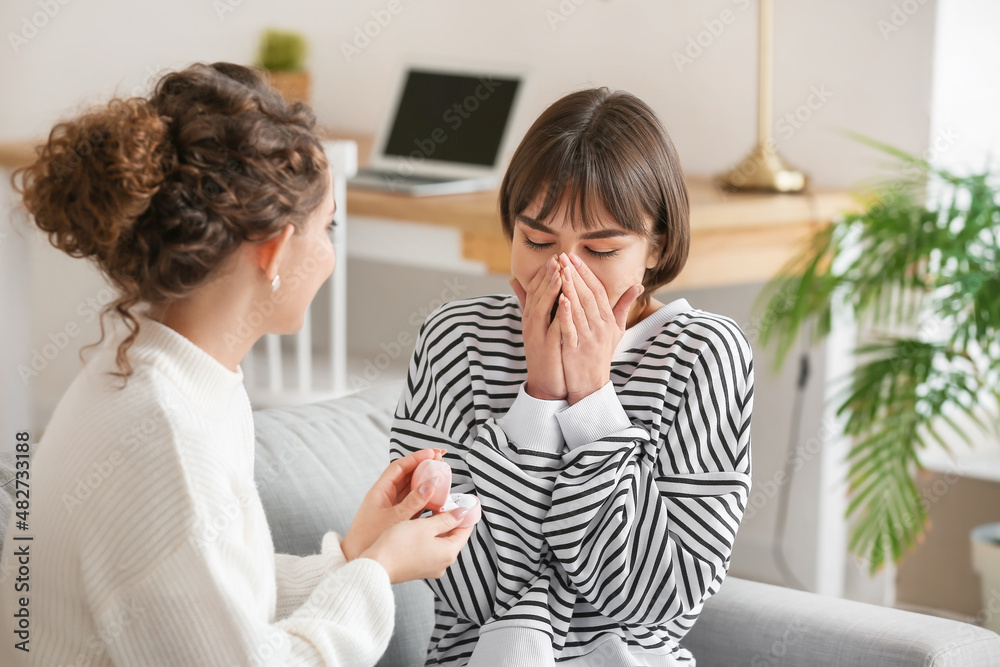 Young lesbian woman proposing to her girlfriend at home Young lesbian woman proposing to her girlfriend at home