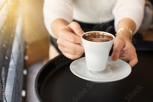 woman hands with turkish coffee on black table