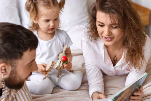 Happy young family reading ...