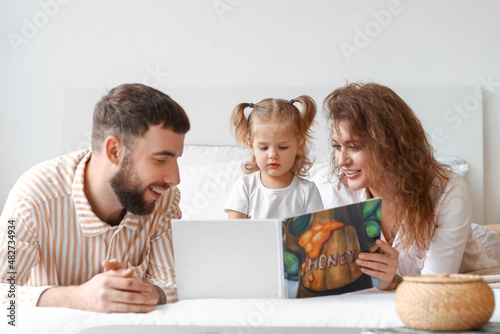 Happy young family reading ...
